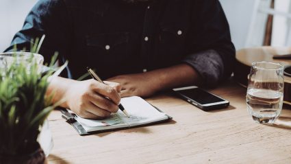 man sitting at desk making checklist for email marketing