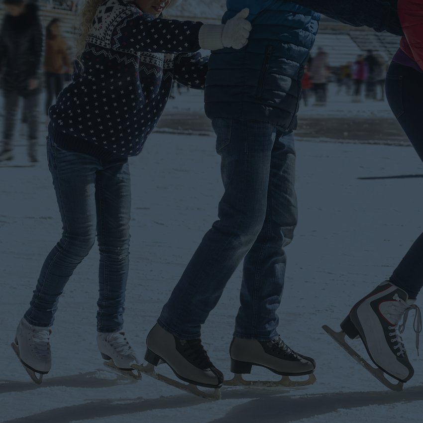 three people ice skating