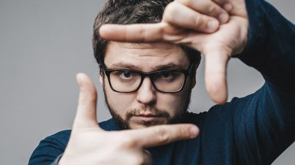 Person looking through framed hands